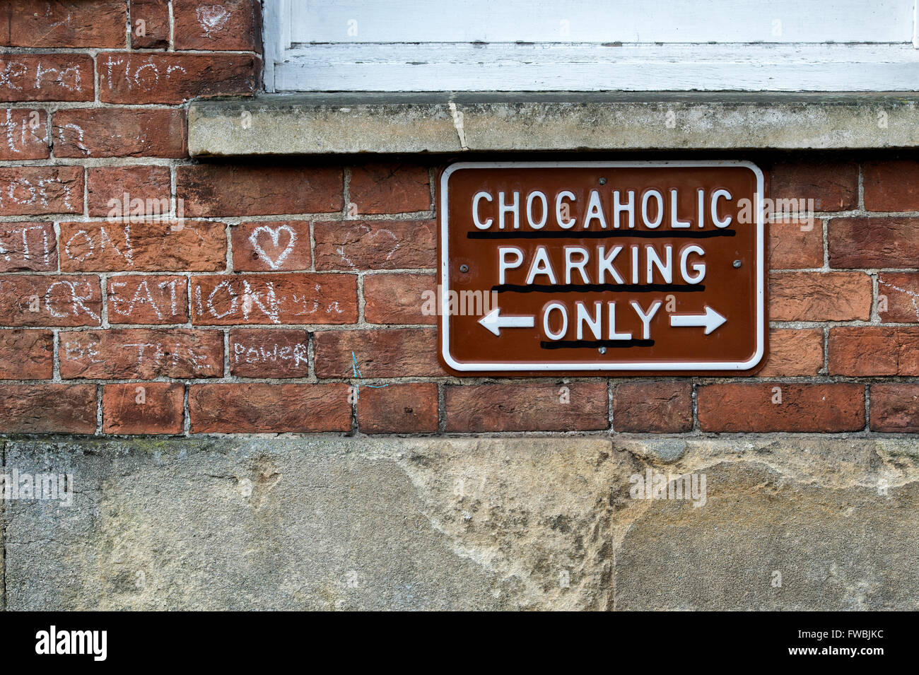 Chocaholic parking only sign on the wall of the Chocolate love temple shop, Glastonbury, Somerset, England Stock Photo