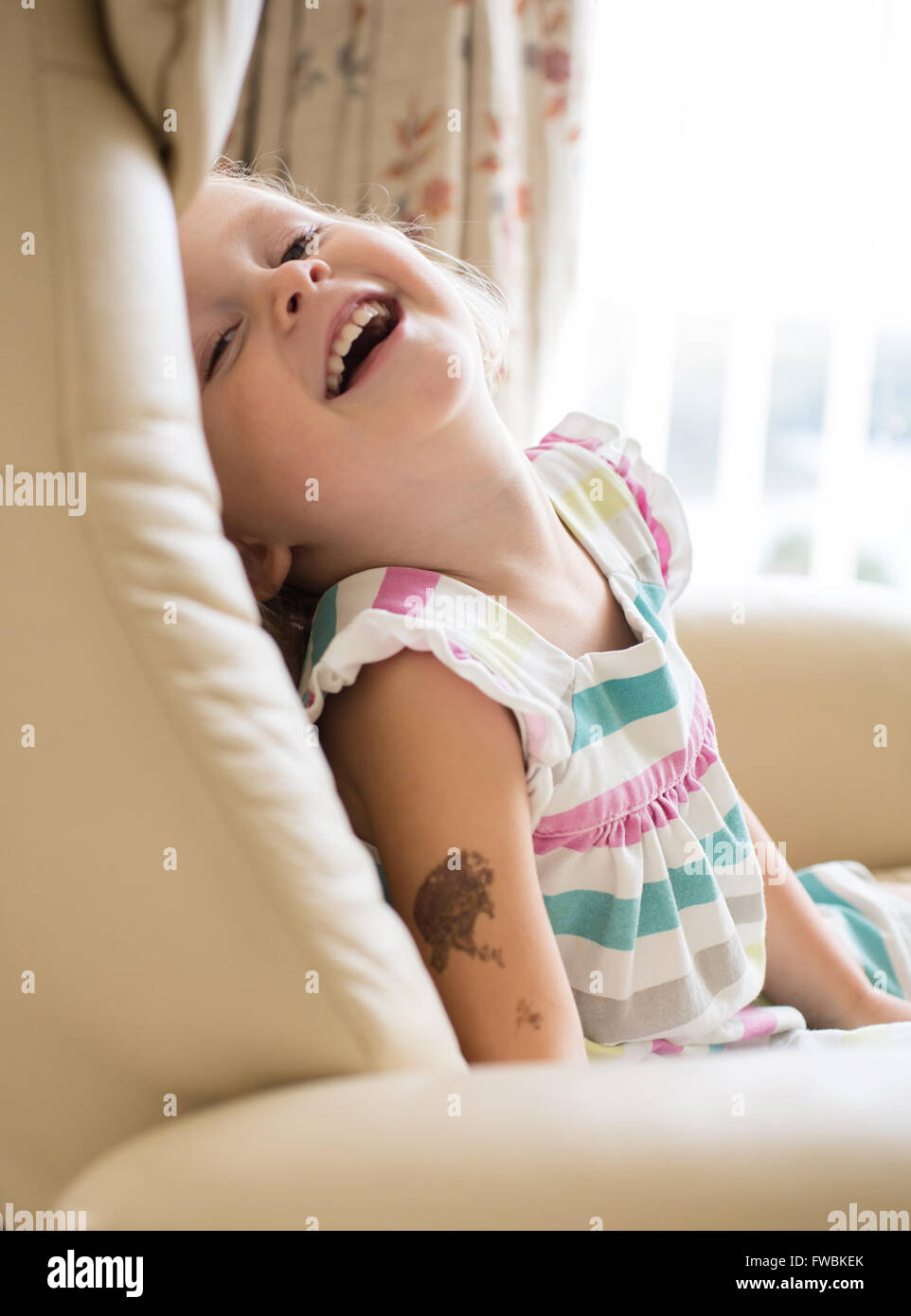 girl on a chair laughing Stock Photo