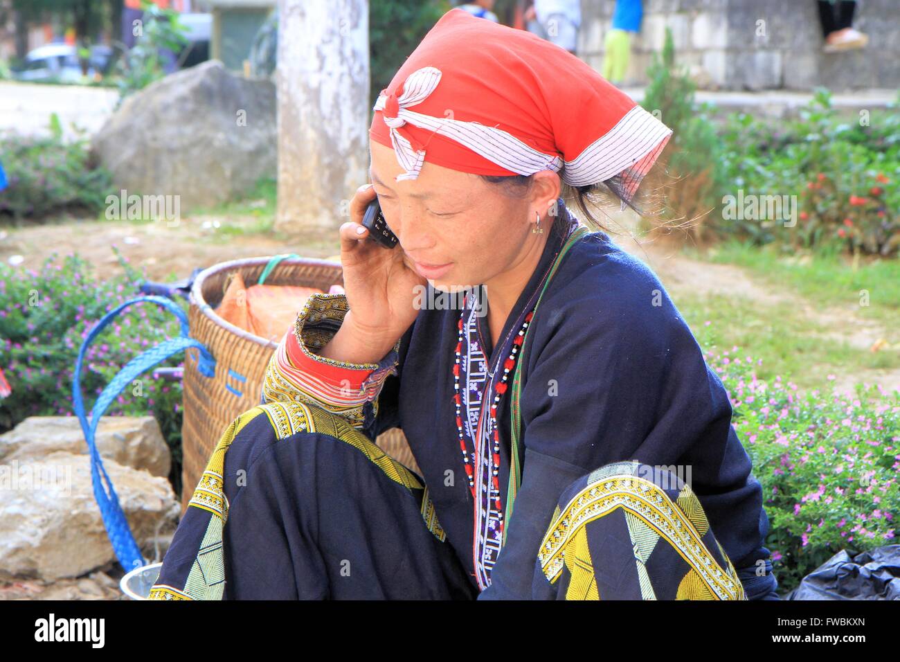 Red Dao woman on her cellphone at market, Sapa, Vietnam, Asia Stock Photo