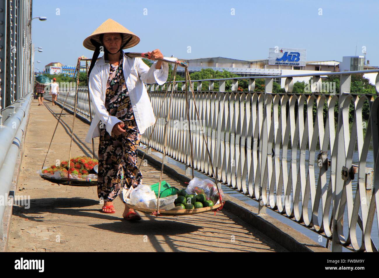 Vietnamese lady carrying baskets os fruits and vegetables, Hue, Vietnam, Asia Stock Photo