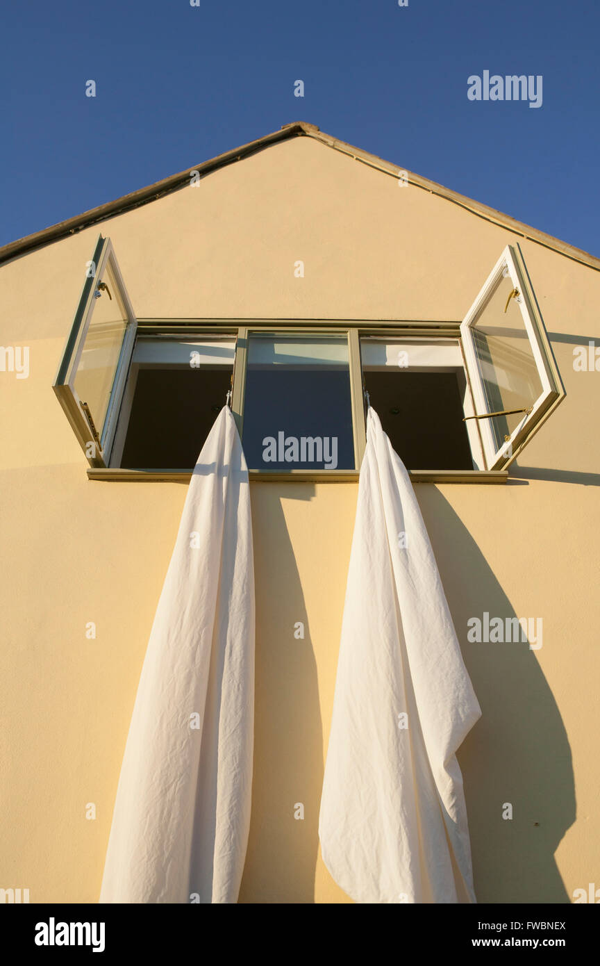 Two sheets hung from the upper floor windows of a house in the sunshine ...