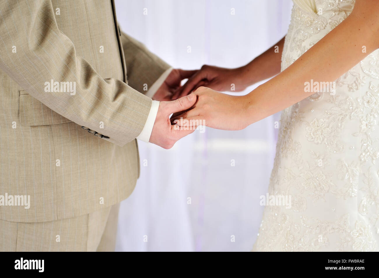 Bride and groom holding his hands Stock Photo