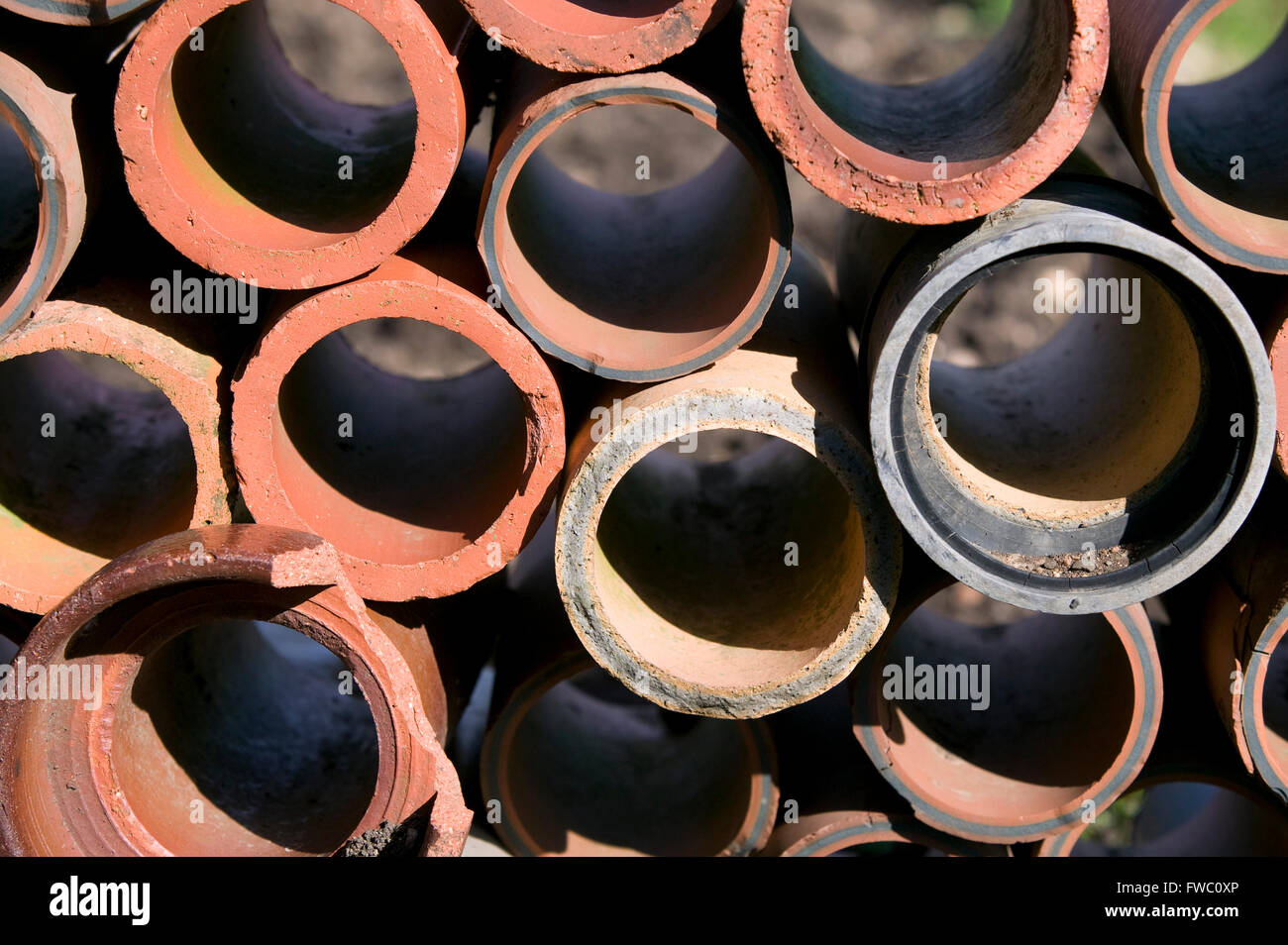 Terracotta pipes stacked on an allotment Stock Photo Alamy