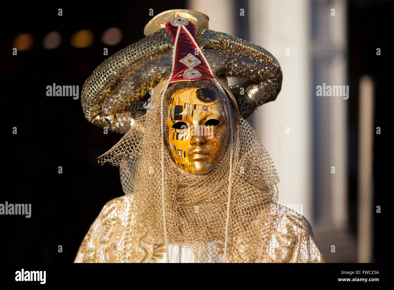 Golden mask at the Venice Carnival in Saint Mark's Square, Venice, Veneto, Italy. Stock Photo