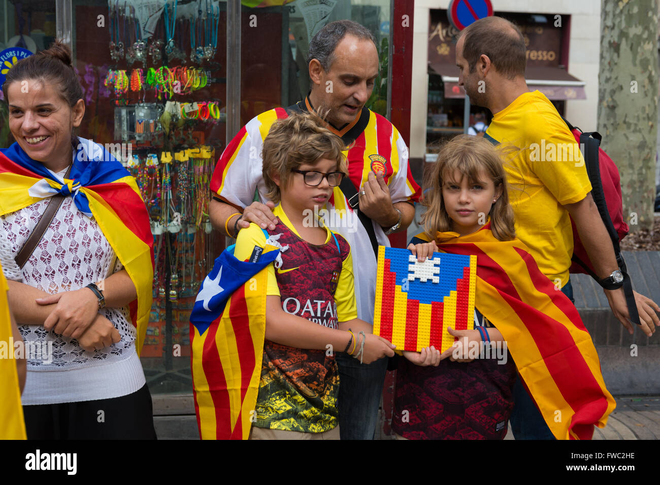 Boy and girl holding flag of Catalonia made with Lego on National Day of Catalonia, Barcelona, Spain Stock Photo