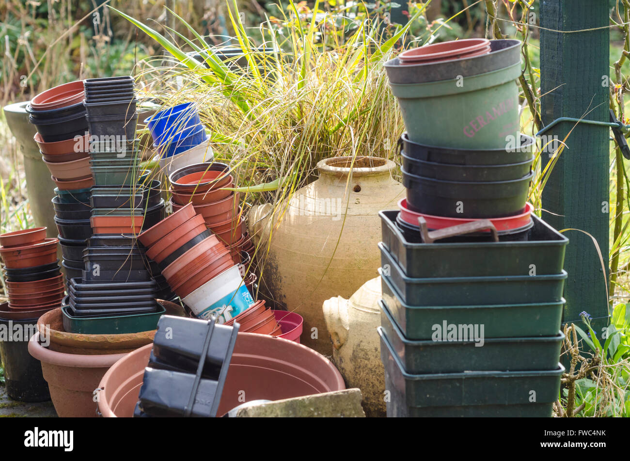Stacks of plastic and terracotta pots outside in a garden Stock Photo
