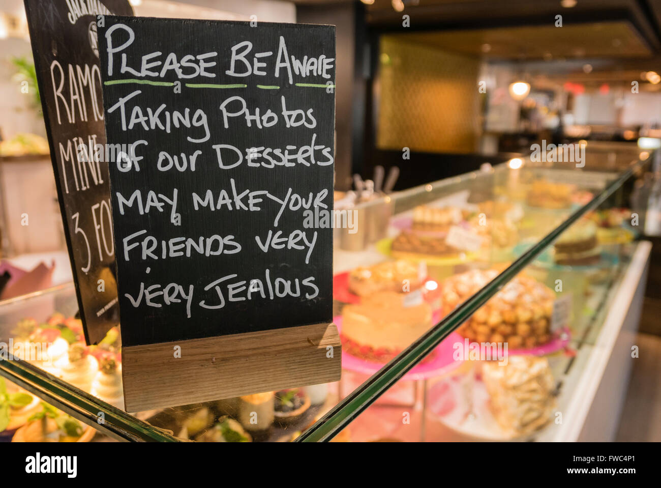 Sign at a restaurant warning customers that photographs of desserts may make your friends very jealous Stock Photo