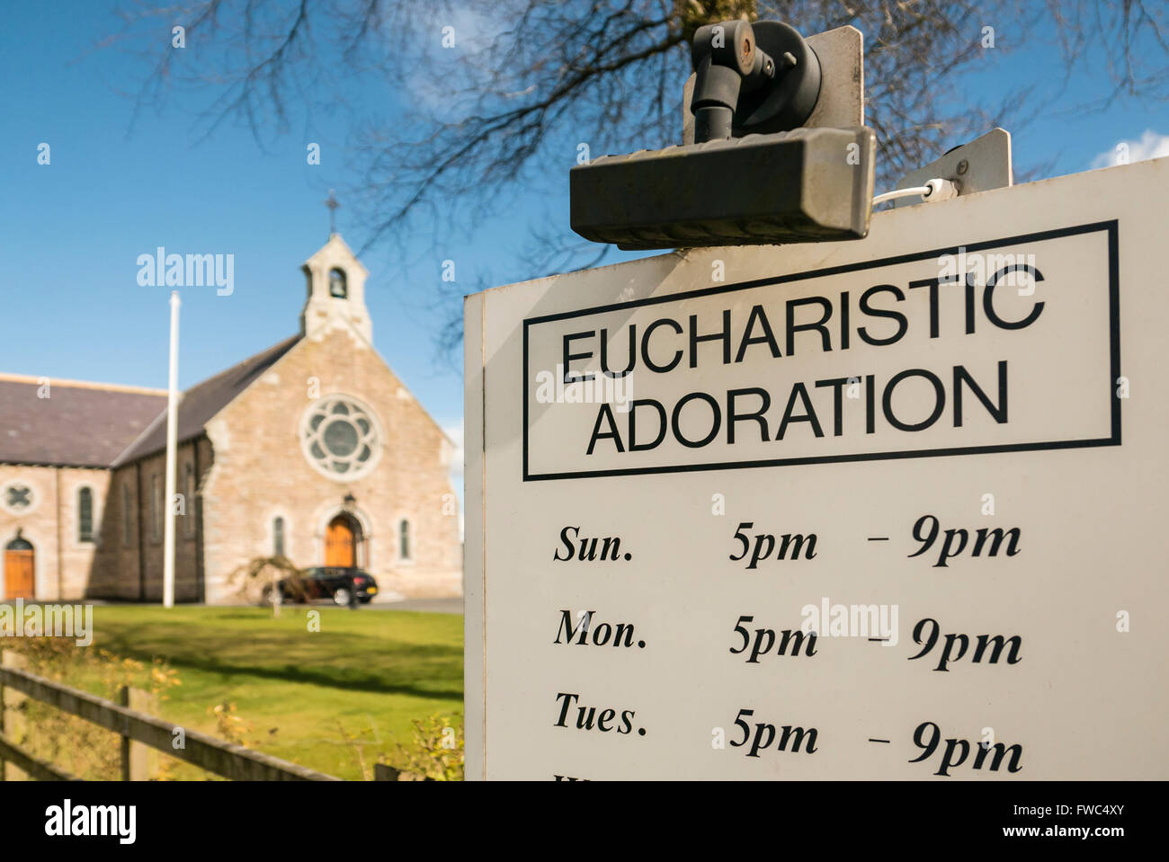 Sign outside a Catholic Church giving times for Eucharistic Adoration. Stock Photo