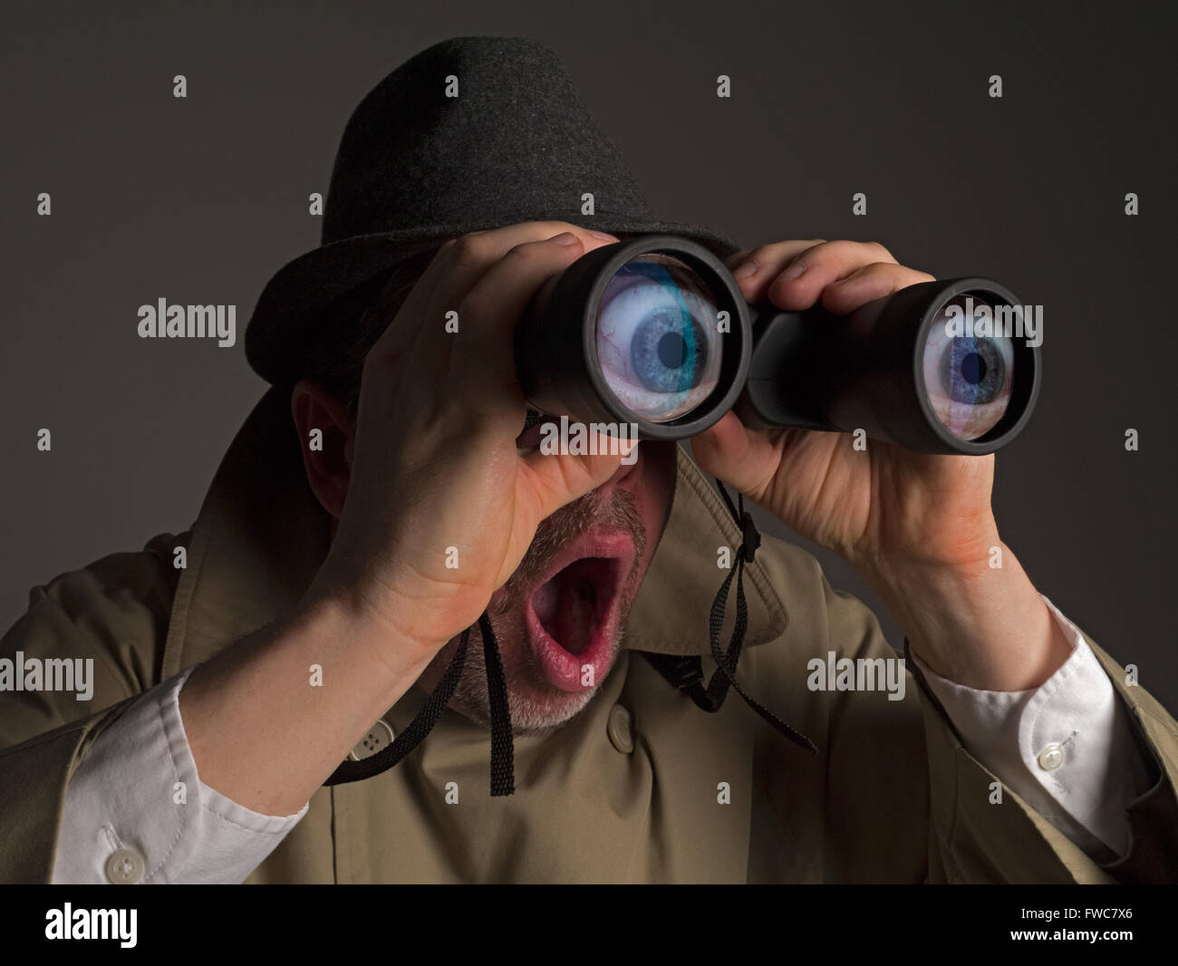 Shocked spy with big cartoon eyes and binoculars Stock Photo