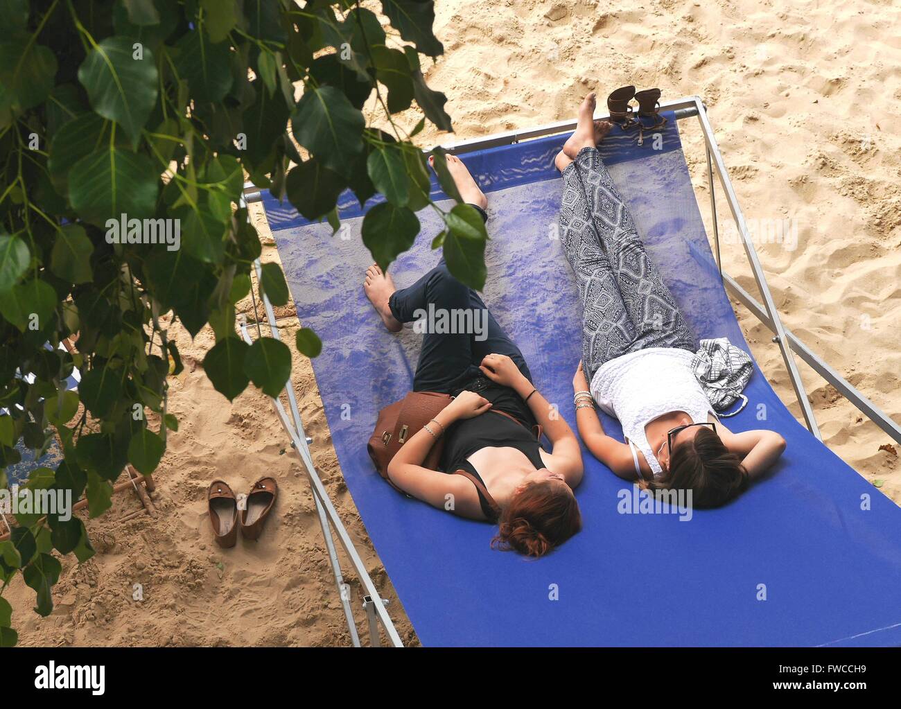 A couple relax in a giant deckchair on Paris Plage, Paris Stock Photo