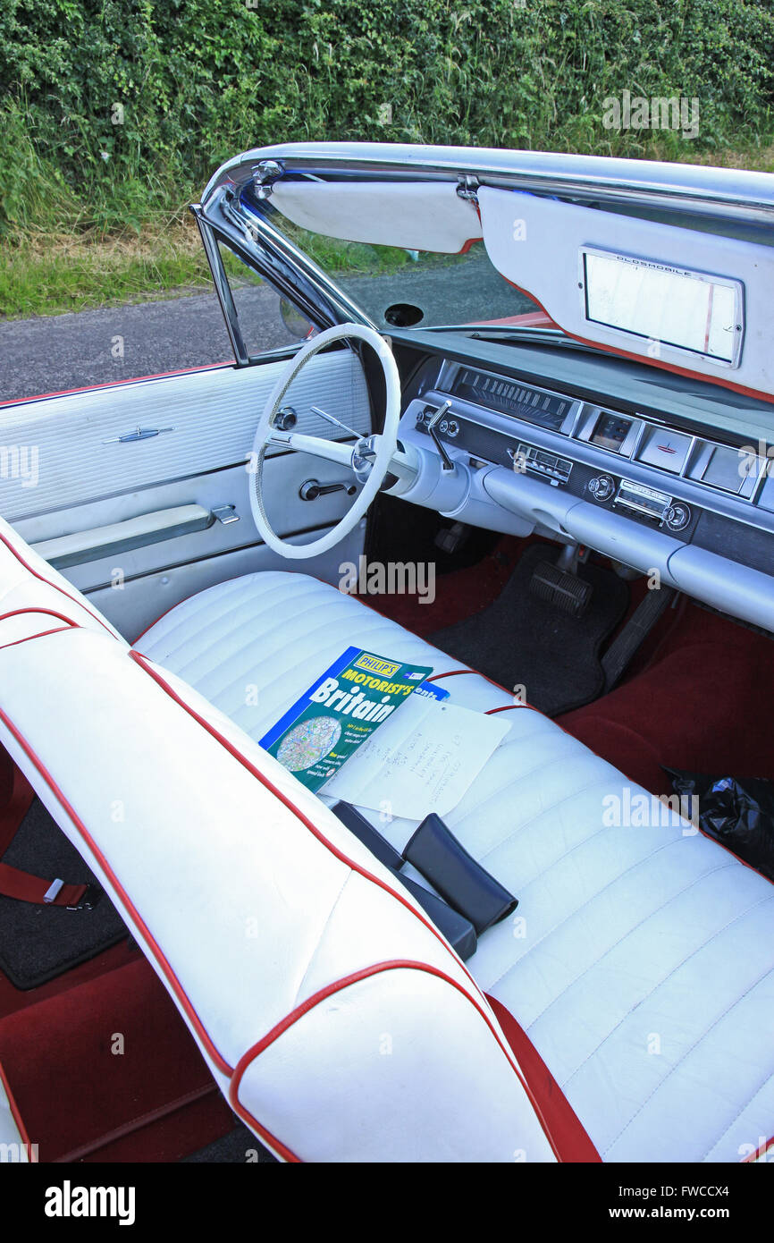 Red Oldsmobile convertible American classic car with white cream
