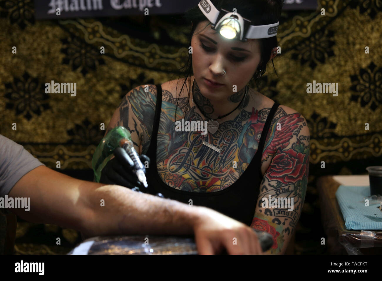 Kathmandu, Nepal. 3rd Apr, 2016. An artist tattoos a visitor during the