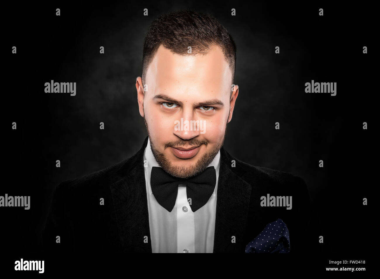 Young handsome man in black suit on dark background Stock Photo - Alamy