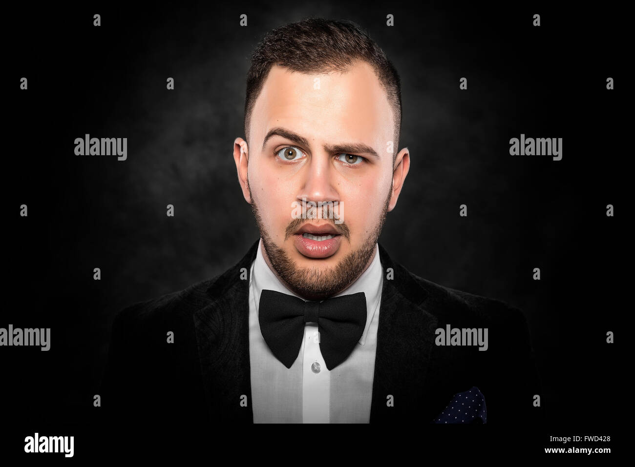 Young handsome man in black suit on dark background Stock Photo - Alamy