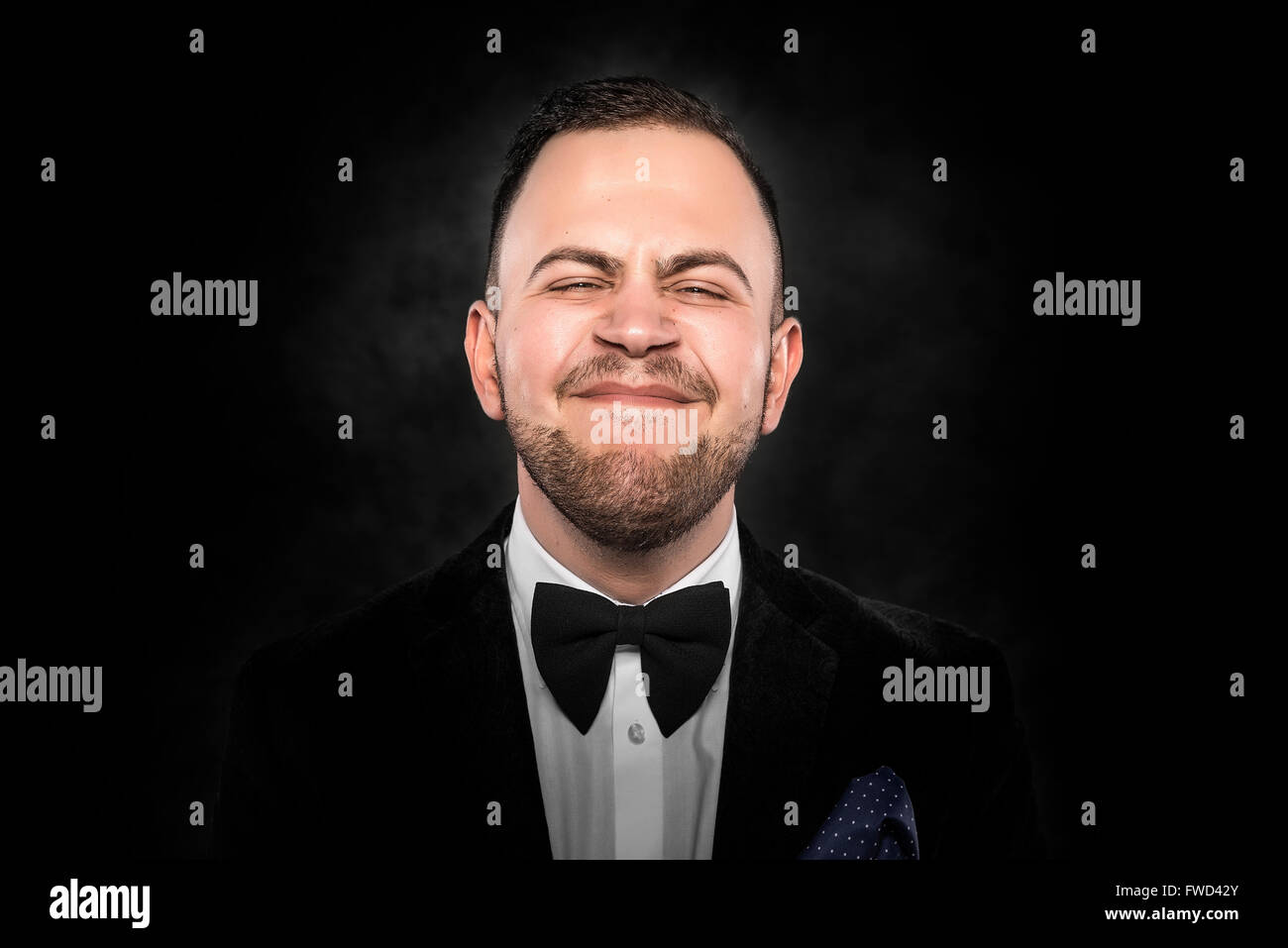 Man in suit makes funny face over dark background Stock Photo