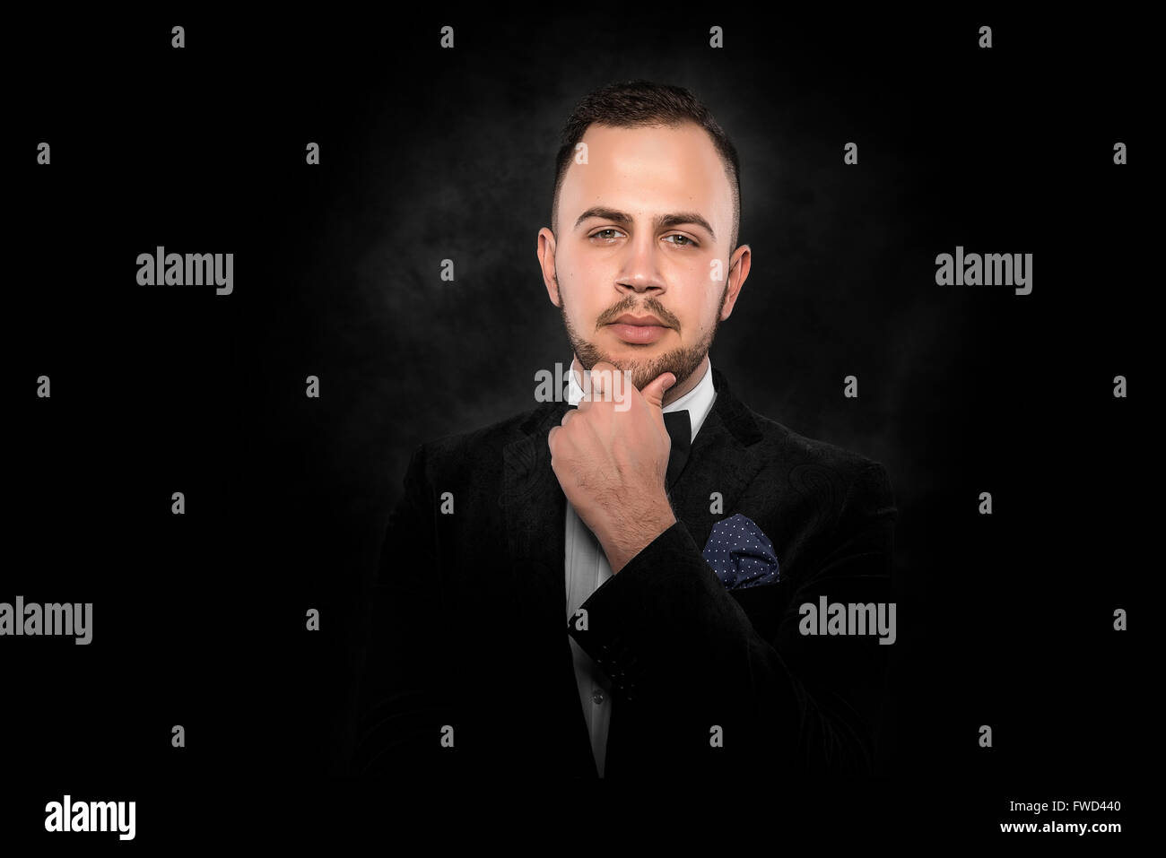 Young handsome man in black suit on dark background Stock Photo - Alamy