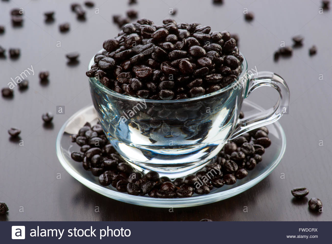 Transparent Glass Cup Filled With Coffee Beans On Dark Wooden Background Transparent Glass Cup Filled With Coffee Beans On Dark Wooden Background
