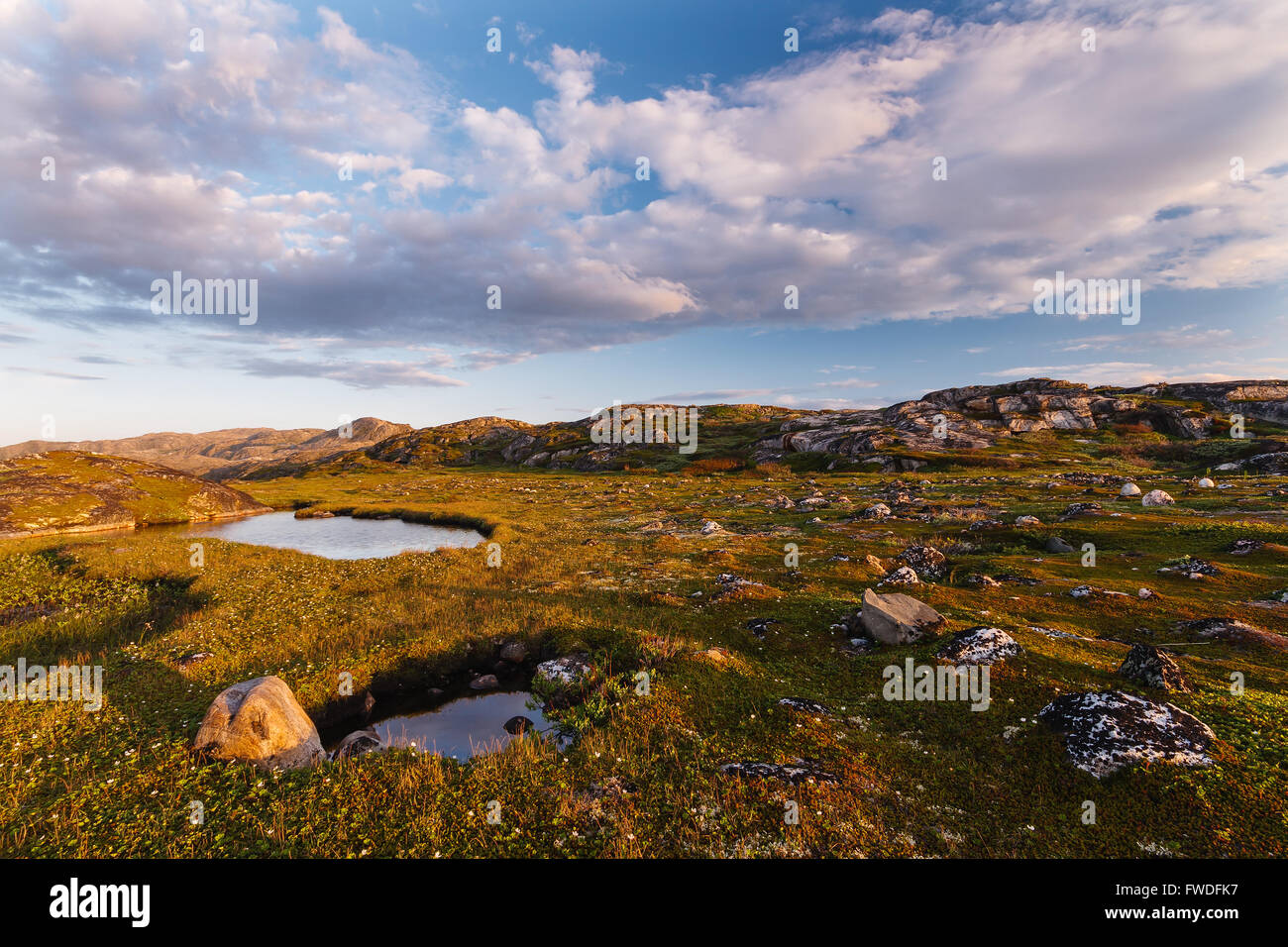 Small lake behind a polar circle lit with the northern summer sun Stock Photo