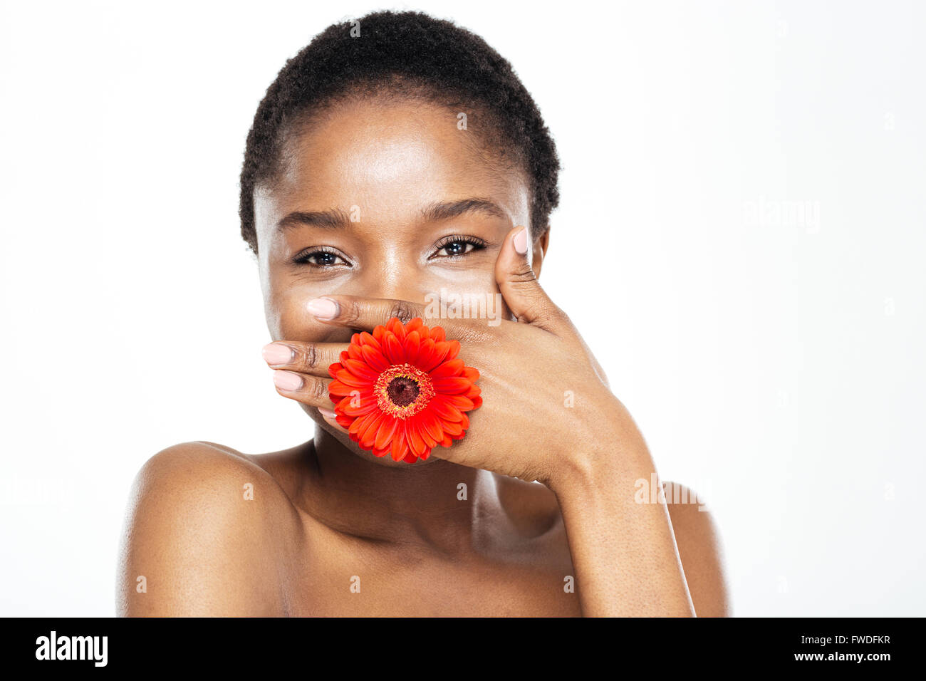 Laughing afro american woman covering her mouth with palm and flowers  isolated on a white background Stock Photo - Alamy