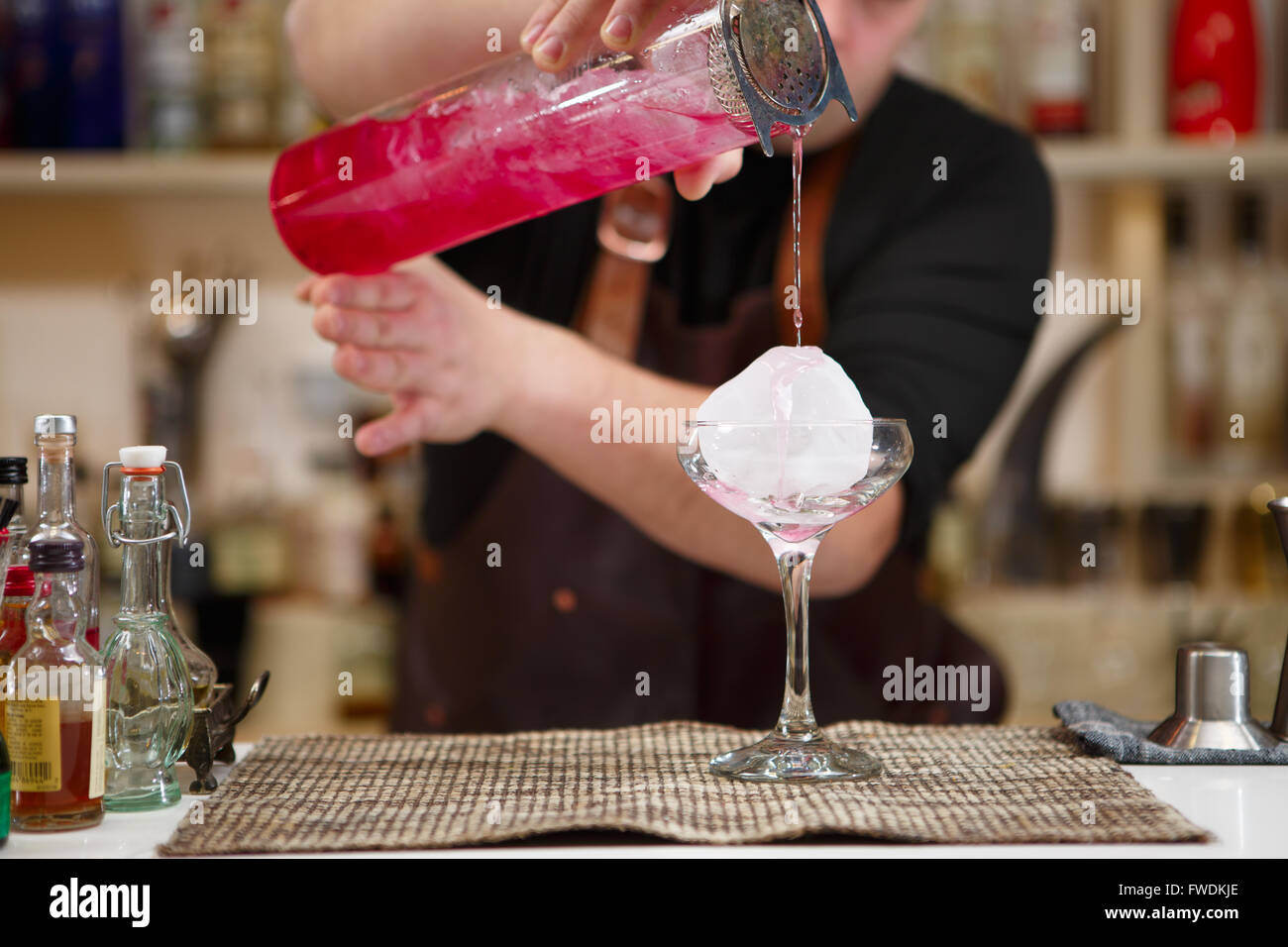 barman pouring a pink cocktail drink Stock Photo