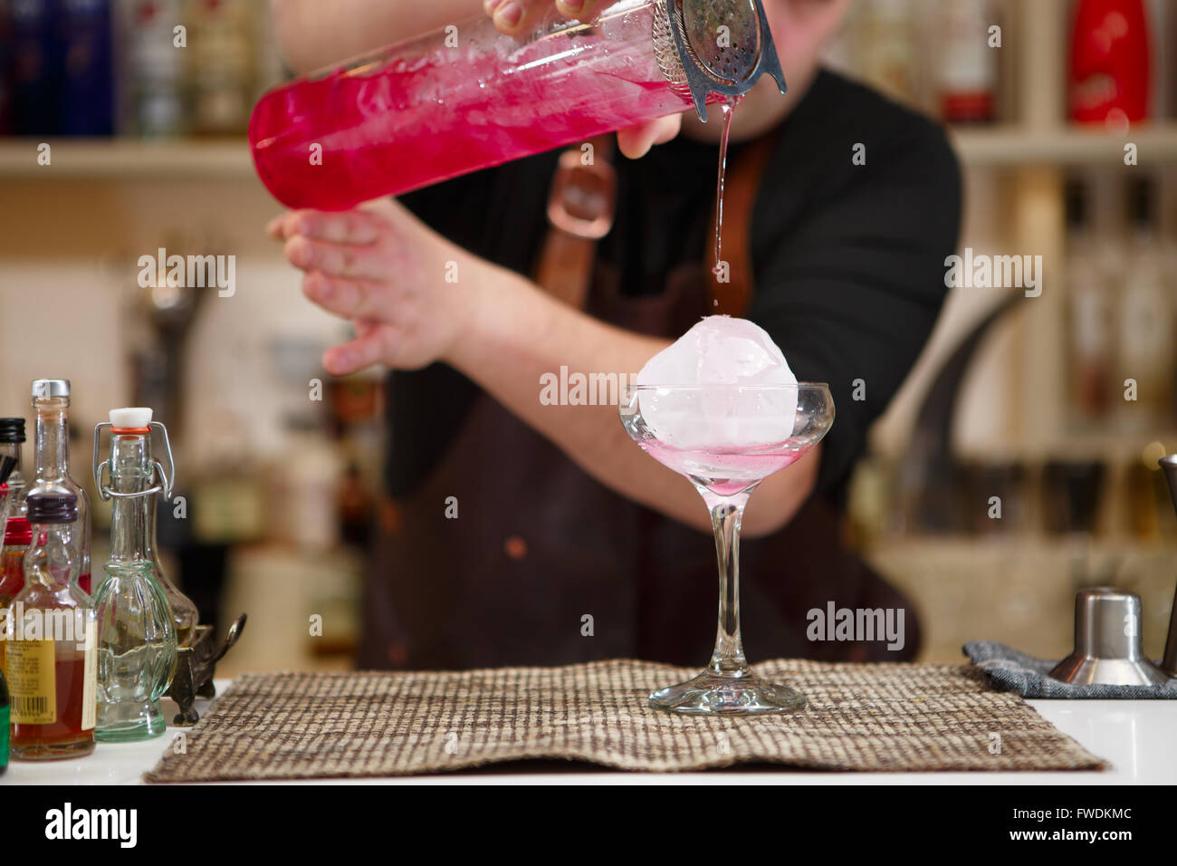 barman pouring a pink cocktail drink Stock Photo