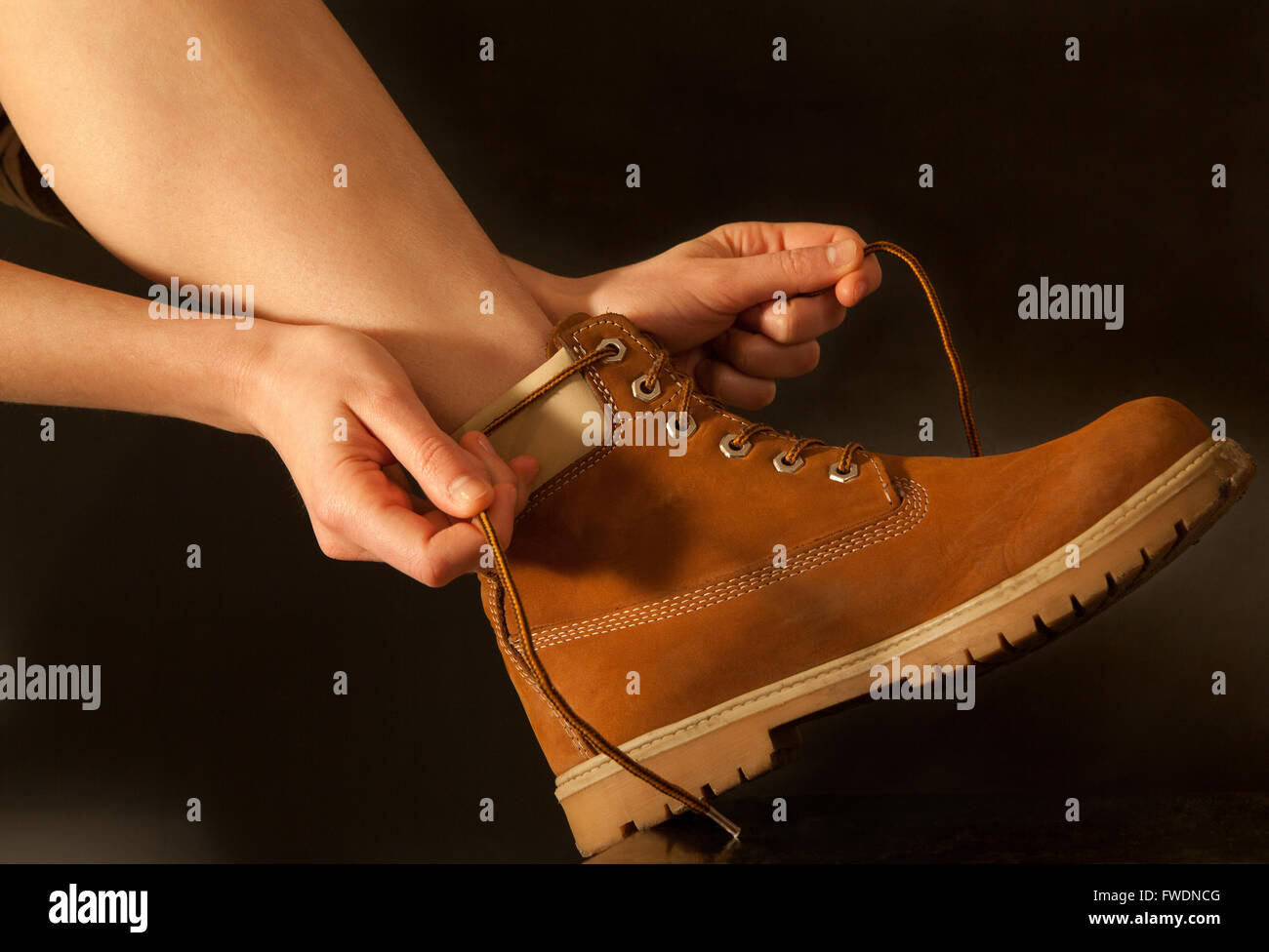 young woman hiker tying shoelaces Stock Photo