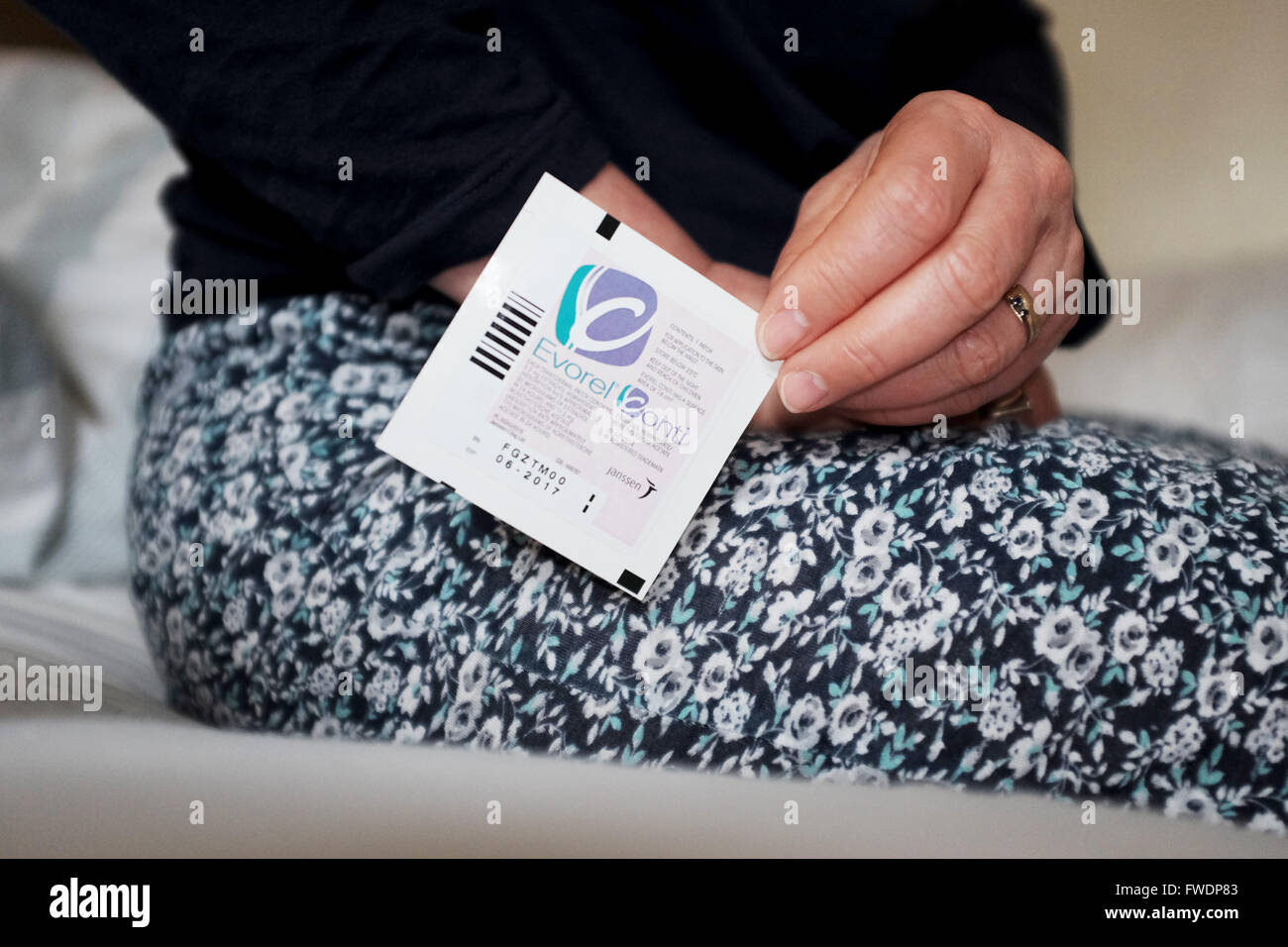 Middle aged woman using Evorel Conti HRT patches to help with the