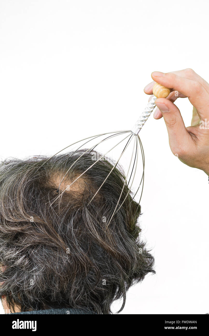 Man relaxes with the Genie head massager. Alternative Therapy. Indian