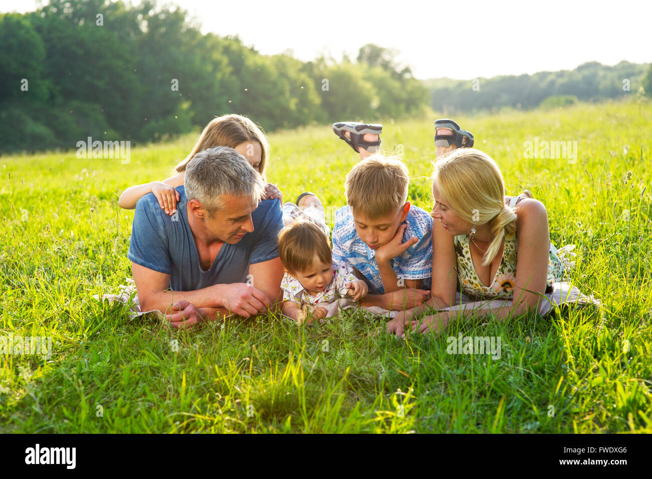 Happy family lying on the grass Stock Photo - Alamy