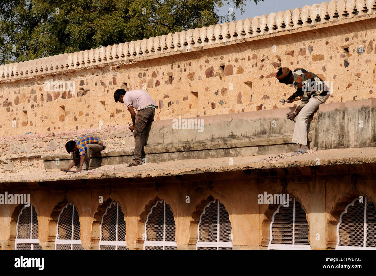 Indian builders at work restoring the roofing for buildings at the Chand Baori Step Well. Stock Photo