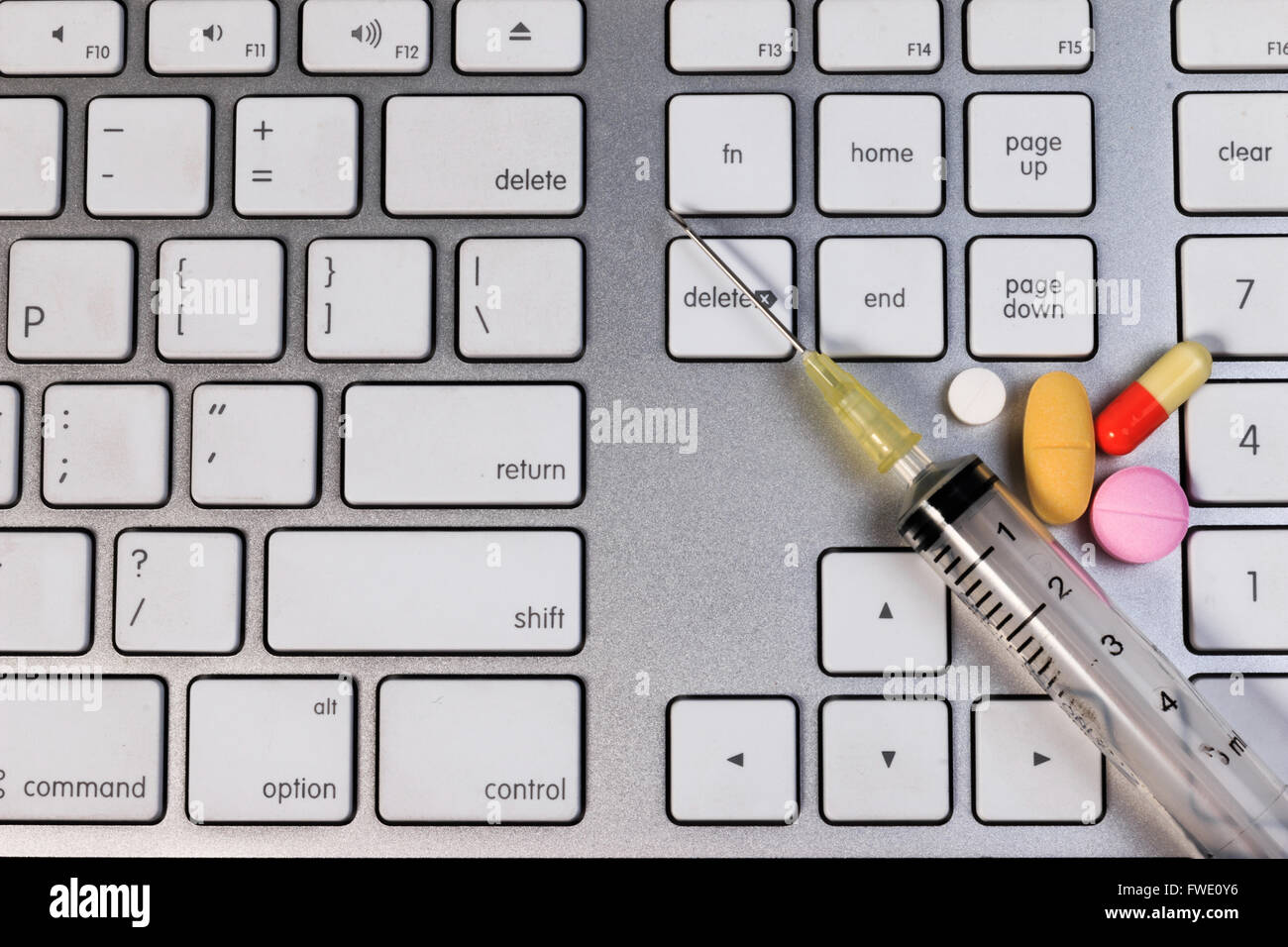 Pills capsule and syringe on computer keyboard, concept on medicine