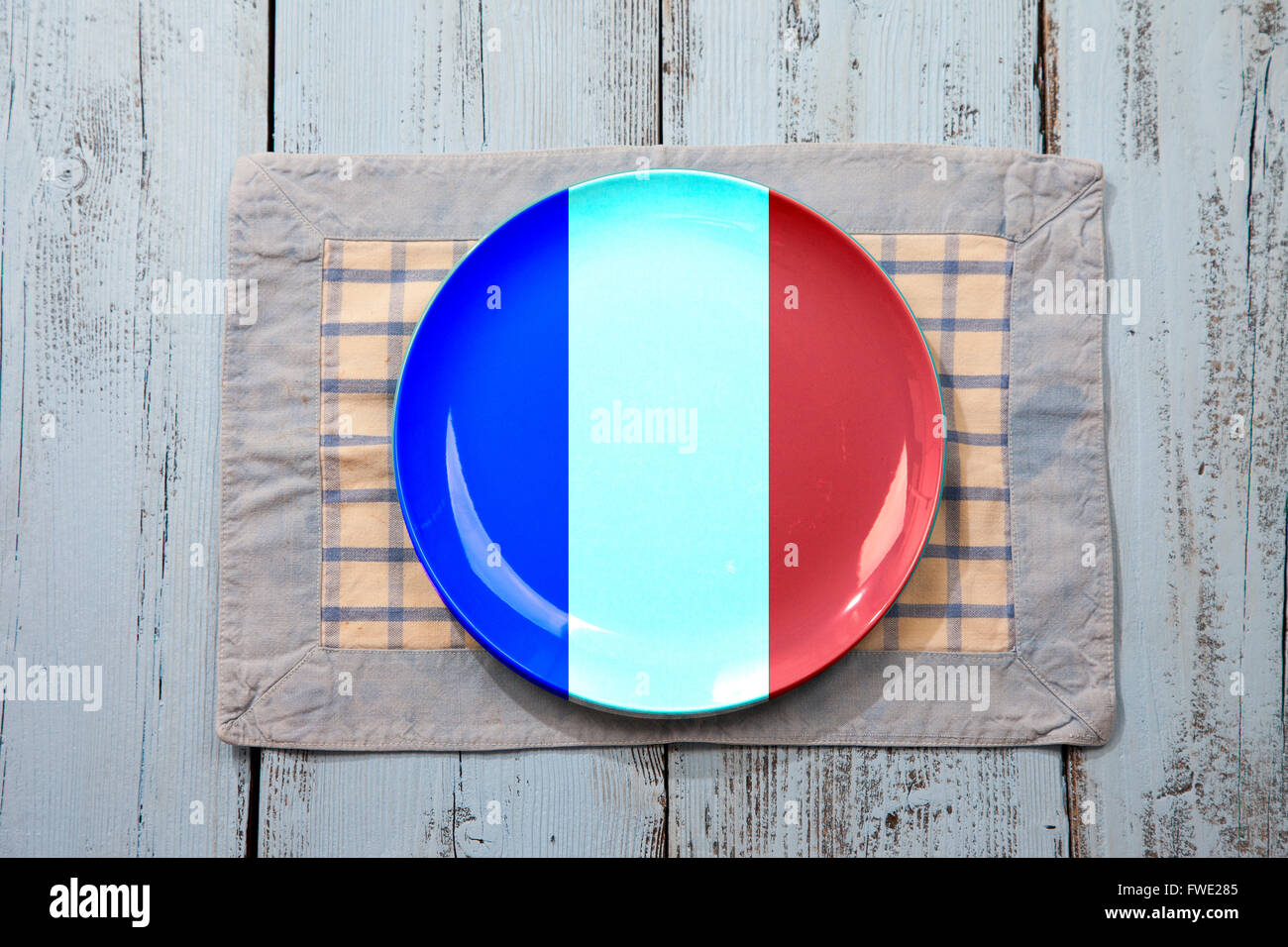 Empty plate with French flag on light blue wooden background Stock Photo