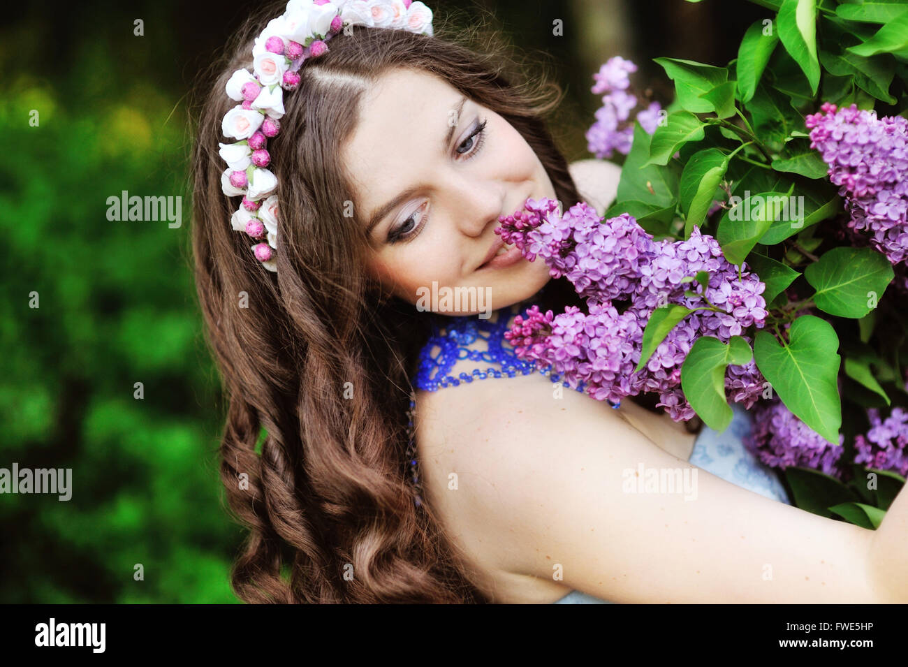 Beautiful girl and blossoming lilac trees Stock Photo