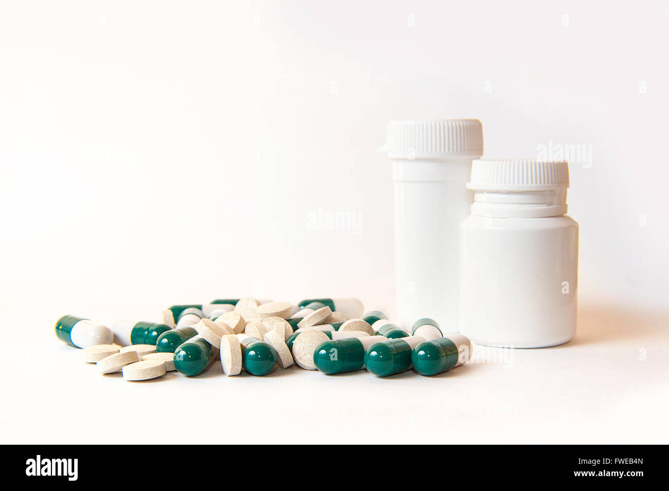 Two white medicine bottle with contents spilled in front Stock Photo