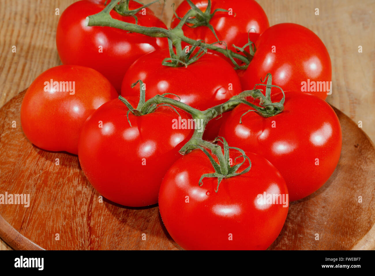 Tomatoes panicles on a wooden chopping board Stock Photo - Alamy