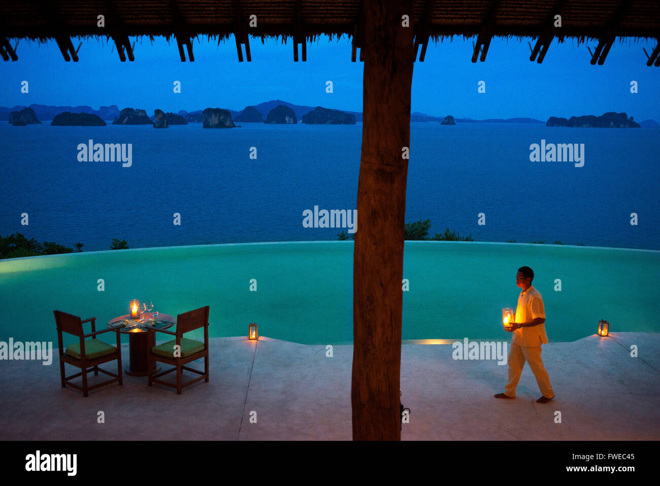 Six Senses Resort, Koh Yao Noi, Phang Nga Bay, Thailand, Asia. Waiter with a candles in the restaurant near the swimming pool ca Stock Photo