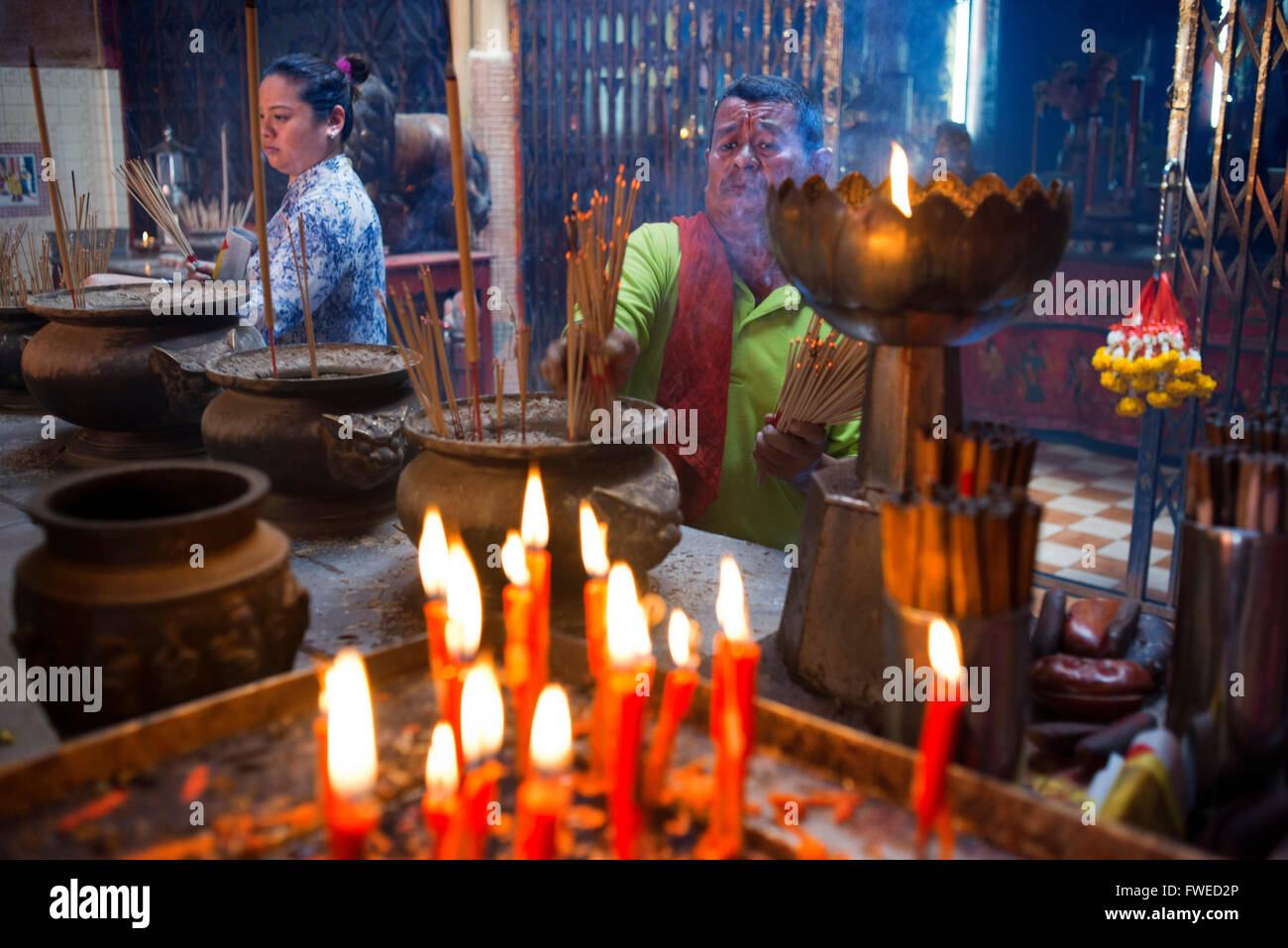 People prayer with candles incense sticks, Temple complex in the Trang