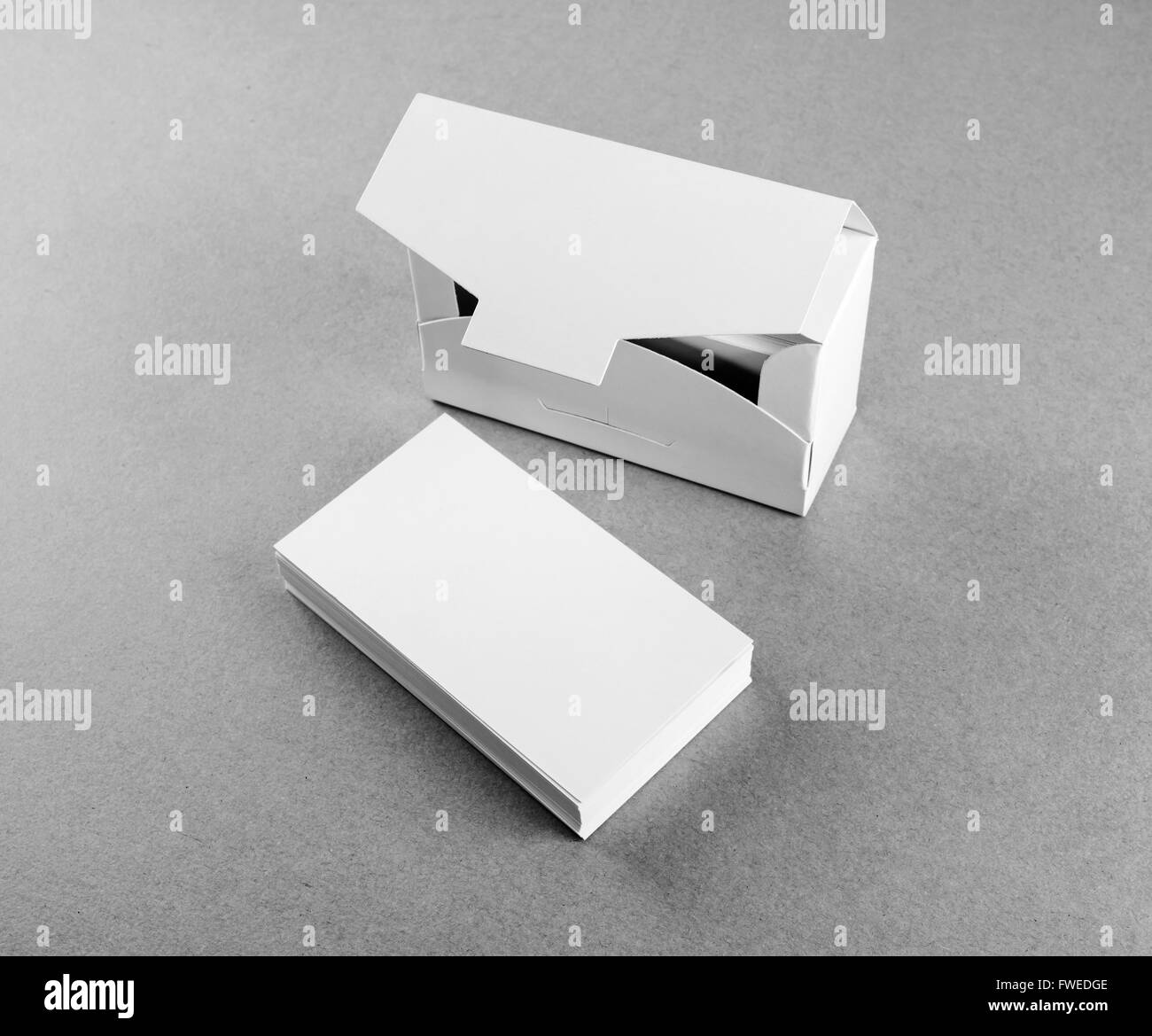 Blank business cards and a box for them on the table. Mock-up for branding identity. Black and white image. Stock Photo