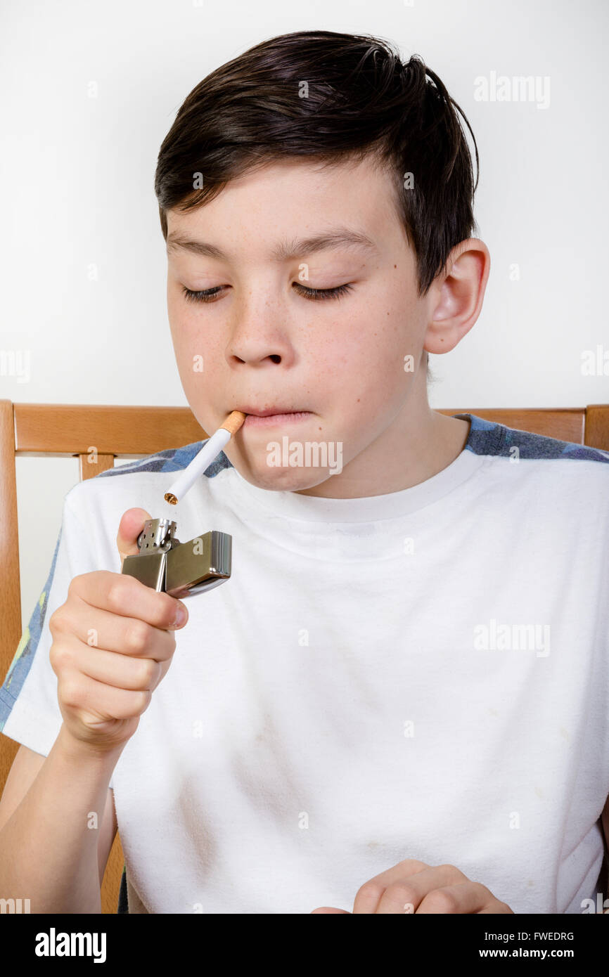 Young boy lighting a cigarette with a lighter Stock Photo Alamy