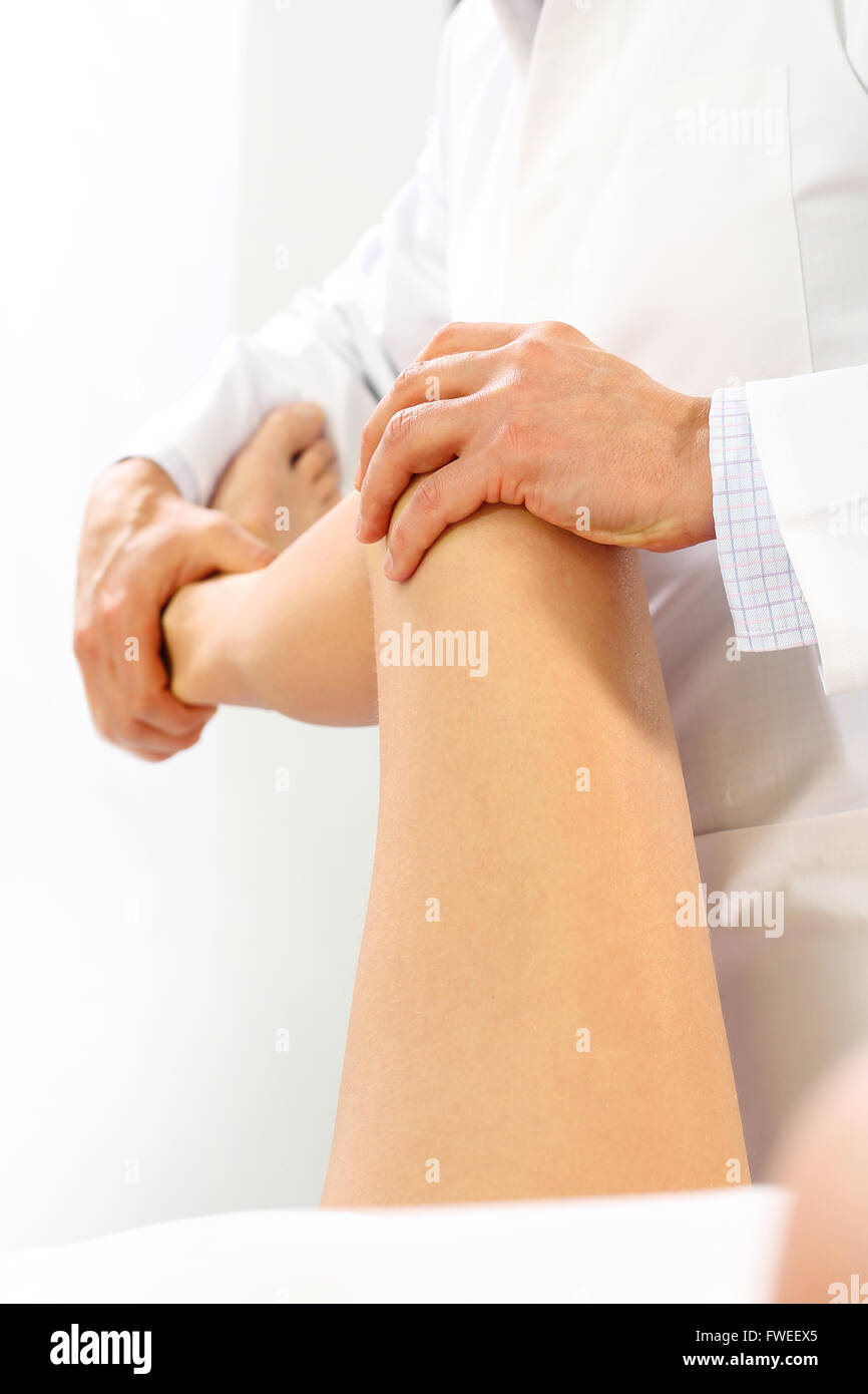 The doctor orthopedist, physical therapist examines the patient's leg. Rehabilitation. The doctor orthopedist Stock Photo