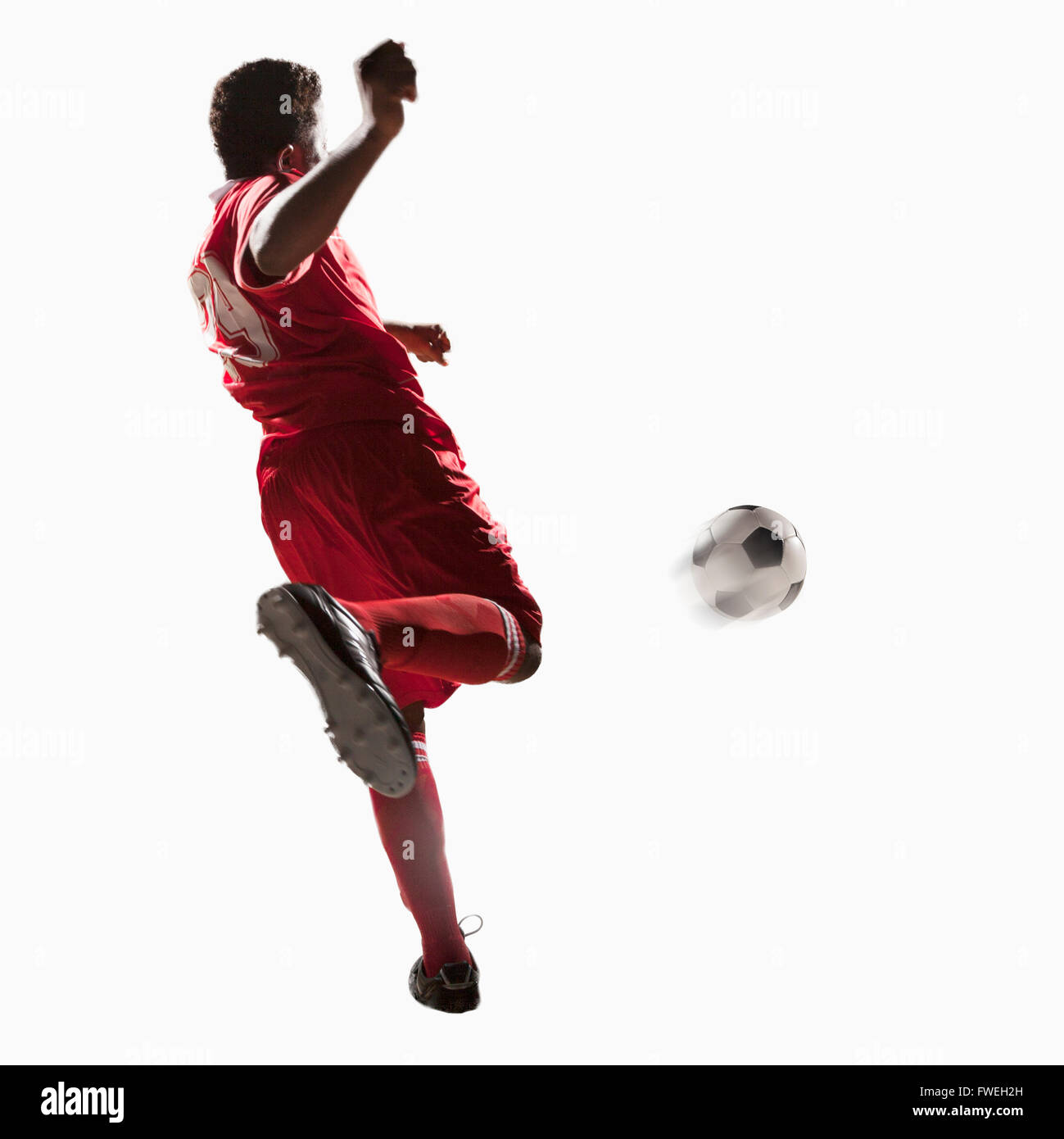 Soccer player kicking soccer ball Stock Photo - Alamy