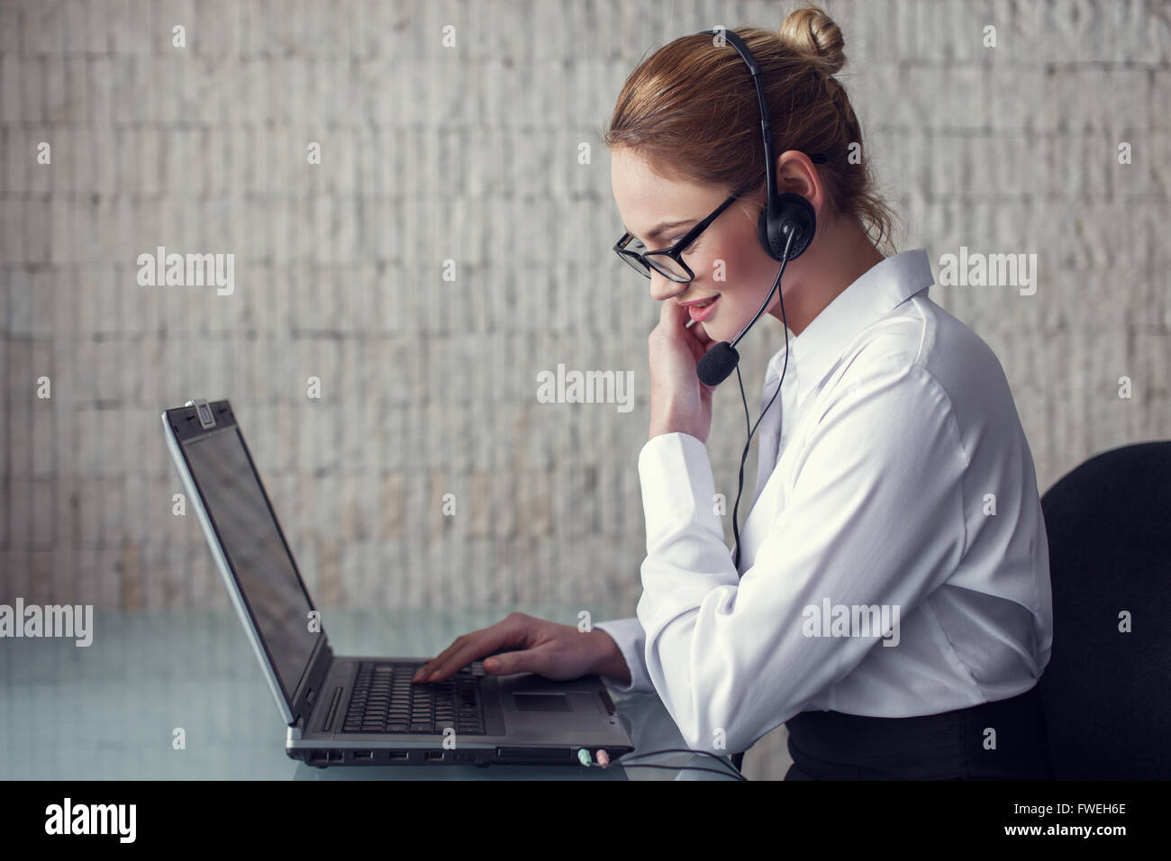 Female customer support emloyee talking online in office Stock Photo