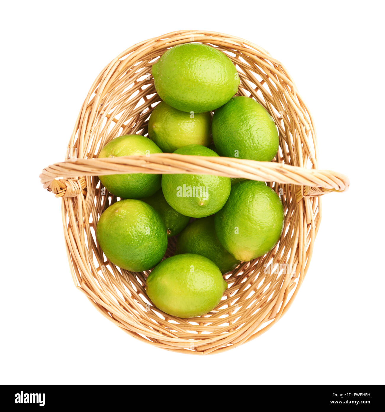 Wicker basket full of multiple ripe limes, composition isolated over ...