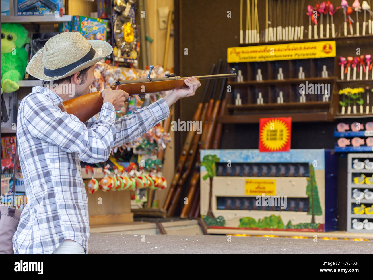 a german man fires with a gun on a shooting gallery on amusement park Stock Photo - Alamy