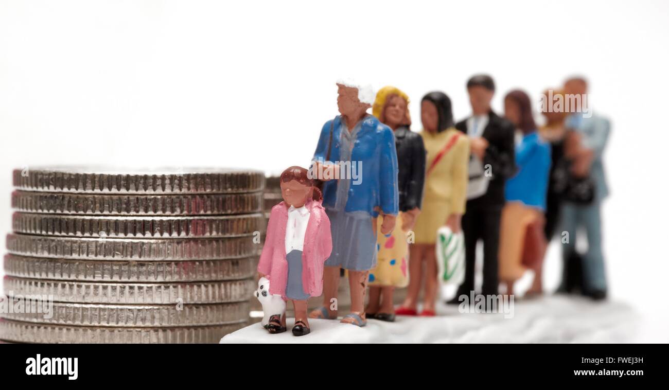 A queue of miniature figurine people next to a pile of coins Stock Photo