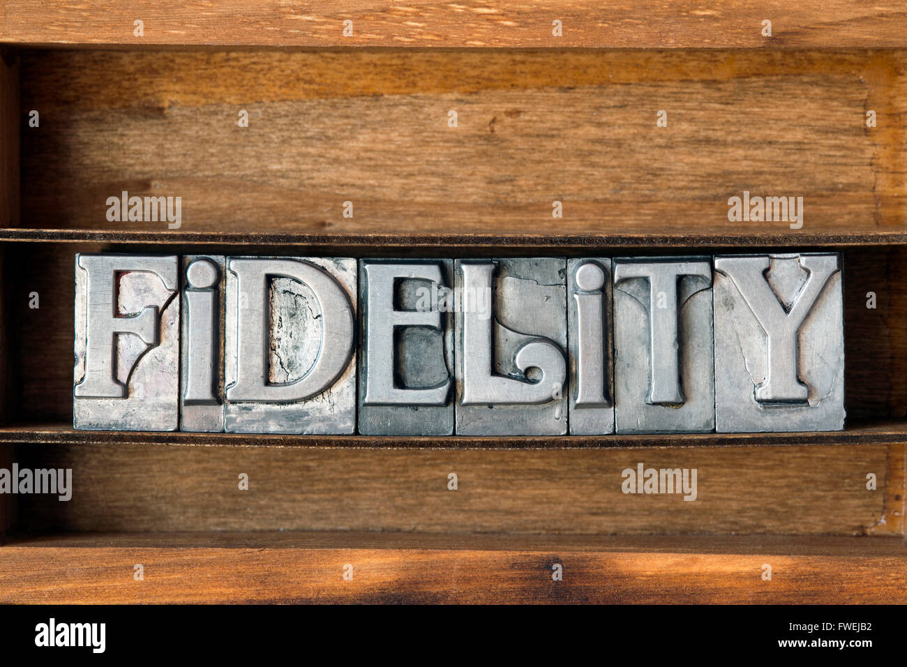 fidelity word made from metallic letterpress type on wooden tray Stock Photo