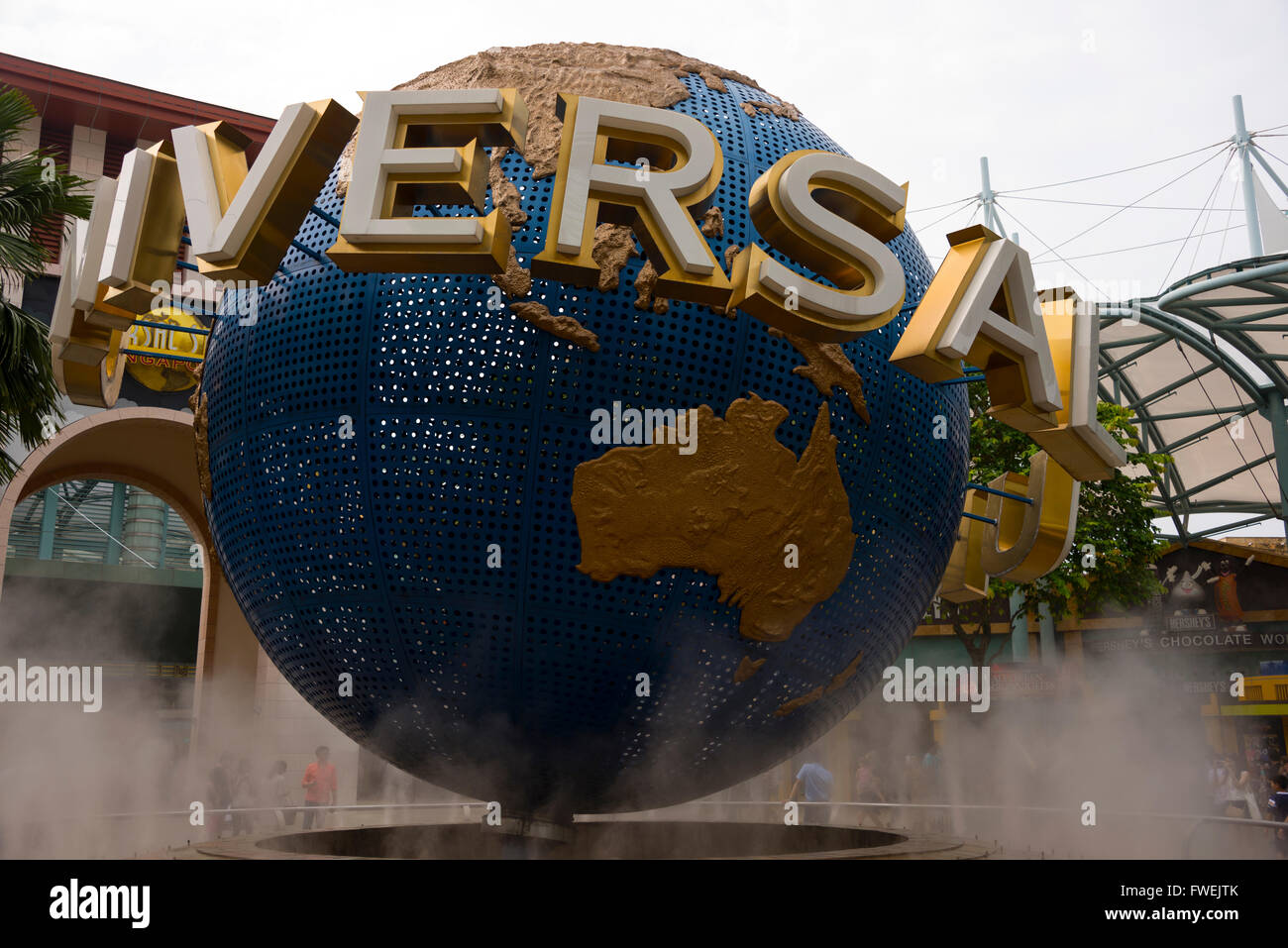Visitors admiring the swirling mist around the revolving globe at Universal Studios on Sentosa Island in Singapore. Stock Photo