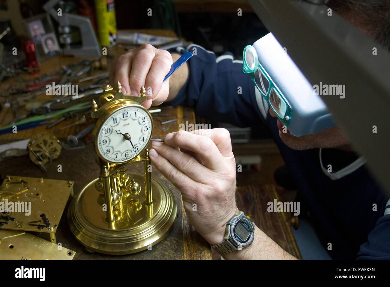 A watchsmith works on repairing a customers clock Stock Photo Alamy