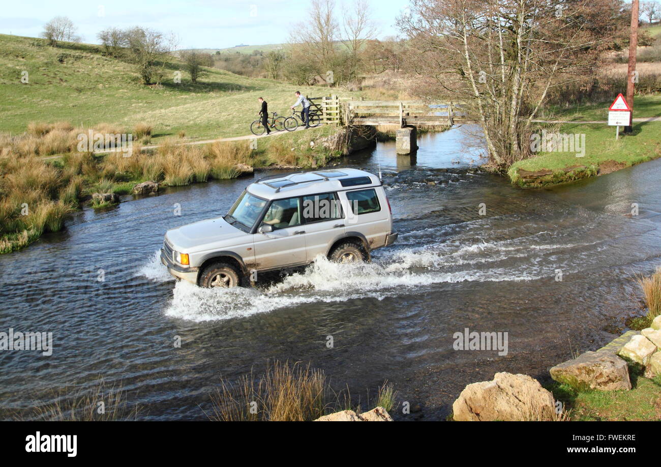 A 4x4 vehicle crosses the ford at Tissington in the Derbyshire Dales, England UK Stock Photo
