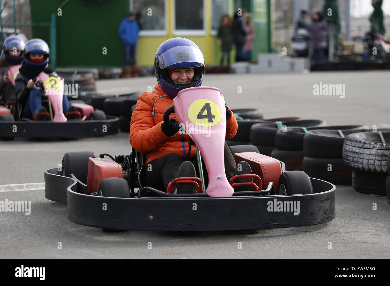 girl is driving Go-kart car with speed in a playground racing track. Go kart is a popular leisure motor sports. Stock Photo